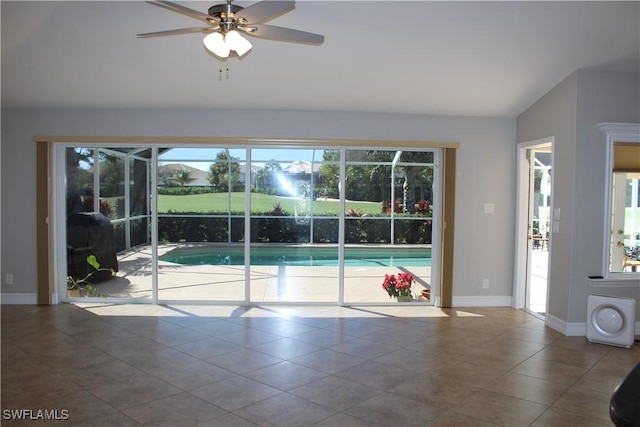 interior space featuring lofted ceiling, tile patterned flooring, baseboards, and a ceiling fan