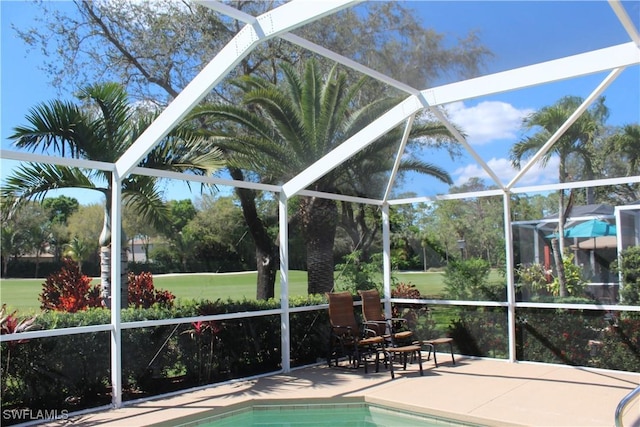 pool with glass enclosure and a patio area