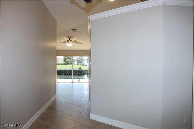 corridor featuring baseboards, ornamental molding, visible vents, and tile patterned floors