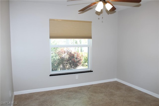 tiled empty room with baseboards and a ceiling fan