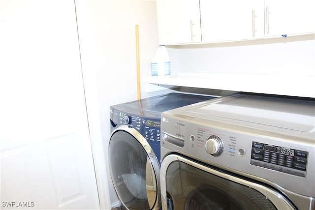 washroom featuring washer and clothes dryer and cabinet space