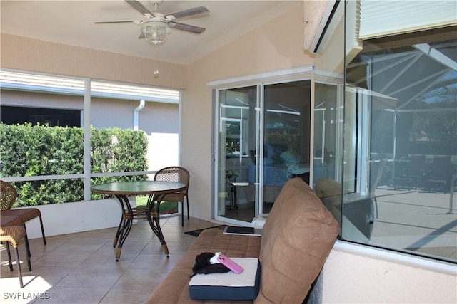 sunroom featuring lofted ceiling and a ceiling fan