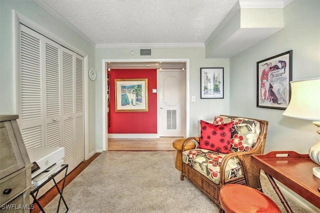 living area featuring a textured ceiling, ornamental molding, and visible vents