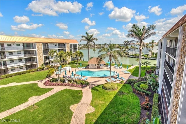 pool with a water view, a lawn, and a patio