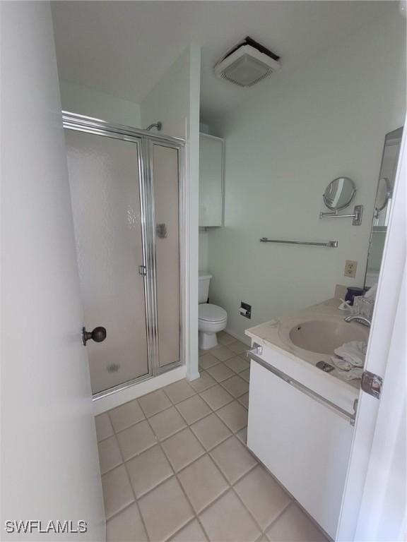 bathroom with a stall shower, vanity, toilet, and tile patterned floors