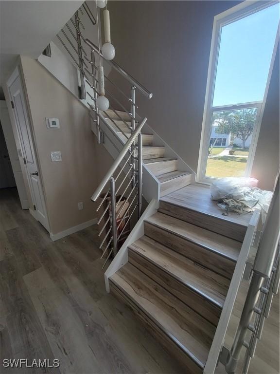 staircase with wood finished floors and baseboards