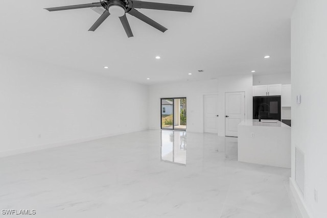 unfurnished living room with marble finish floor, recessed lighting, visible vents, a sink, and ceiling fan