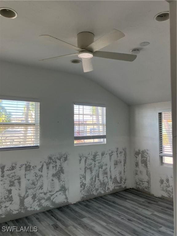 empty room with vaulted ceiling, wood finished floors, and a ceiling fan