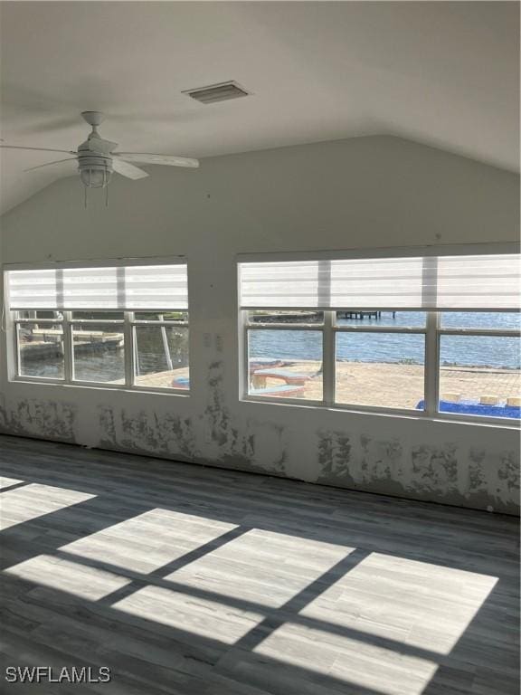 unfurnished sunroom with a ceiling fan, visible vents, and vaulted ceiling