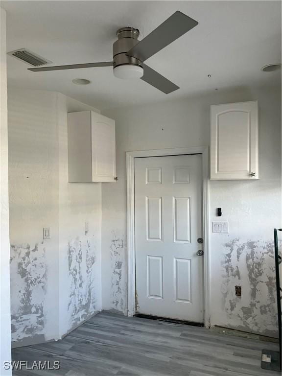 doorway to outside with a ceiling fan, visible vents, and wood finished floors