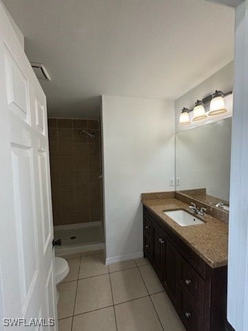 3510 5th St SW, Lehigh Acres, FL 33976 - full bathroom with a tile shower, toilet, vanity, and tile patterned floors