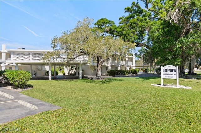 view of home's community featuring uncovered parking and a lawn