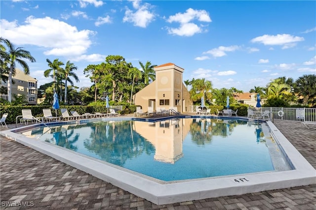 community pool featuring a patio area and fence