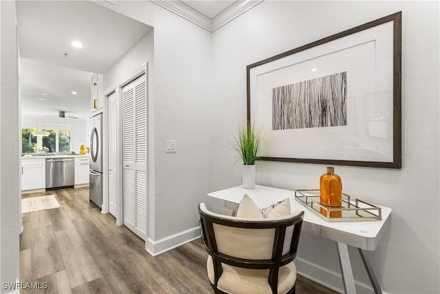 hall with ornamental molding, wood finished floors, and baseboards