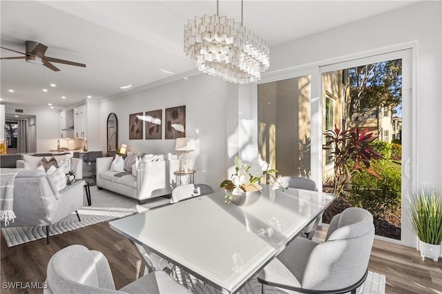 dining room featuring ceiling fan with notable chandelier, wood finished floors, and recessed lighting