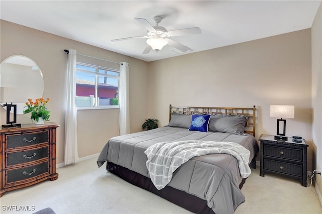 bedroom with light carpet, baseboards, and a ceiling fan