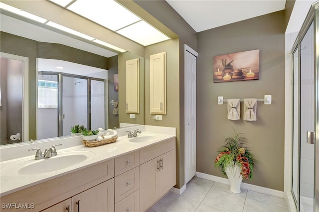 bathroom with double vanity, a stall shower, a sink, and tile patterned floors