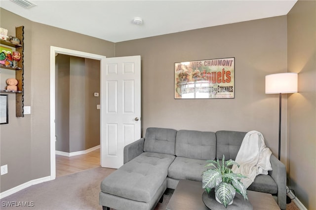 carpeted living area featuring visible vents and baseboards