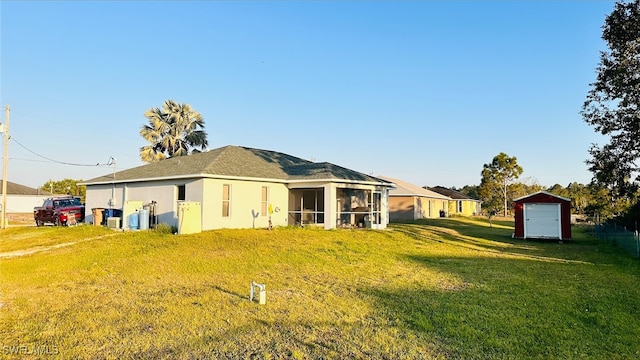 rear view of house featuring a yard and a sunroom