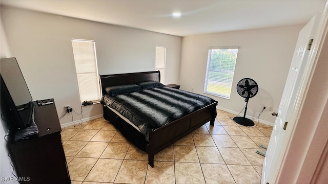 bedroom with light tile patterned floors and baseboards