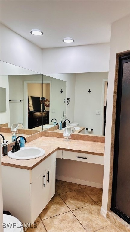 bathroom with double vanity, tile patterned floors, and a sink