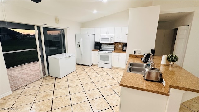 kitchen featuring white appliances, light tile patterned floors, a peninsula, a sink, and tasteful backsplash