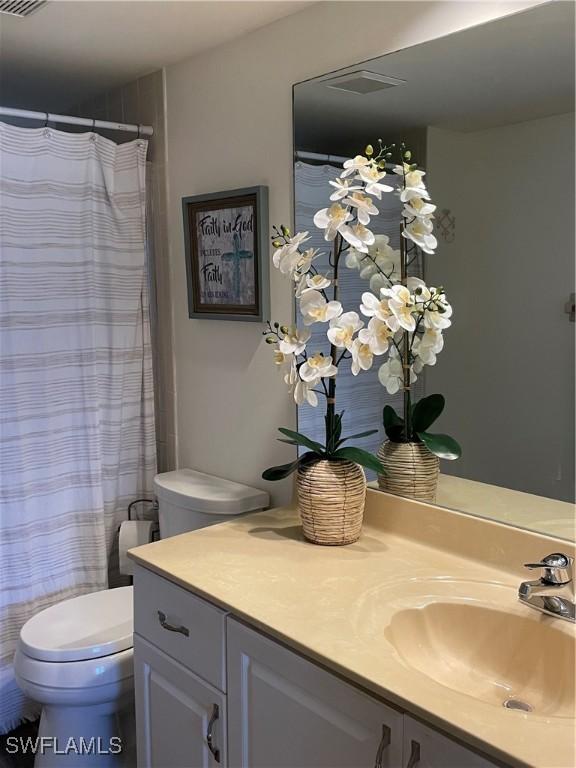 full bathroom with toilet, a shower with curtain, visible vents, and vanity