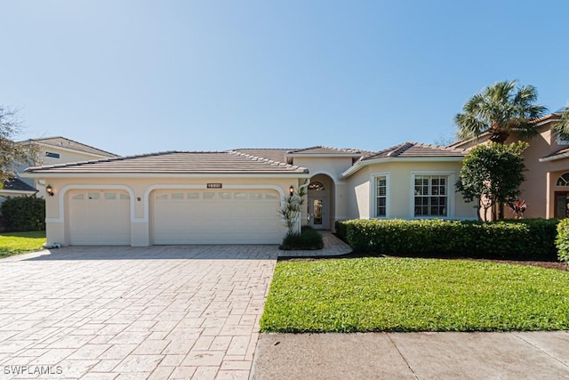 2109 Morning Sun Ln, Naples, FL 34119 - mediterranean / spanish-style home with a tile roof, a front yard, stucco siding, decorative driveway, and a garage