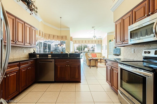 2109 Morning Sun Ln, Naples, FL 34119 - kitchen with ornamental molding, a sink, light tile patterned flooring, a peninsula, and appliances with stainless steel finishes