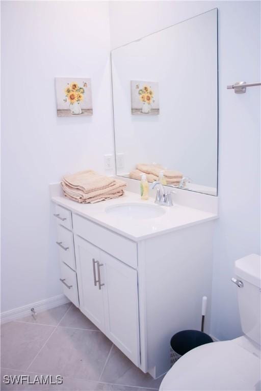 bathroom with baseboards, vanity, toilet, and tile patterned floors