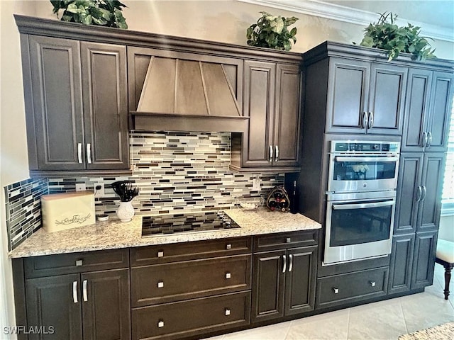 kitchen featuring double oven, tasteful backsplash, black electric cooktop, and custom range hood