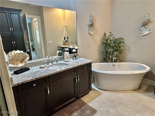 bathroom featuring a freestanding tub, tile patterned flooring, and vanity