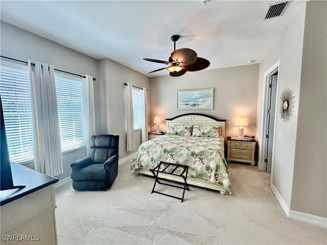 bedroom with baseboards, a ceiling fan, visible vents, and light colored carpet