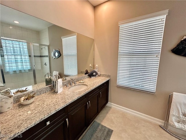 bathroom featuring a stall shower, tile patterned flooring, baseboards, and vanity