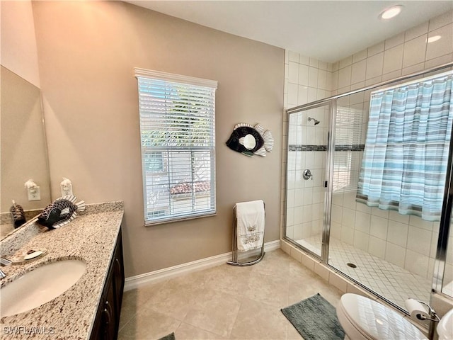 full bath with vanity, a shower stall, toilet, and baseboards