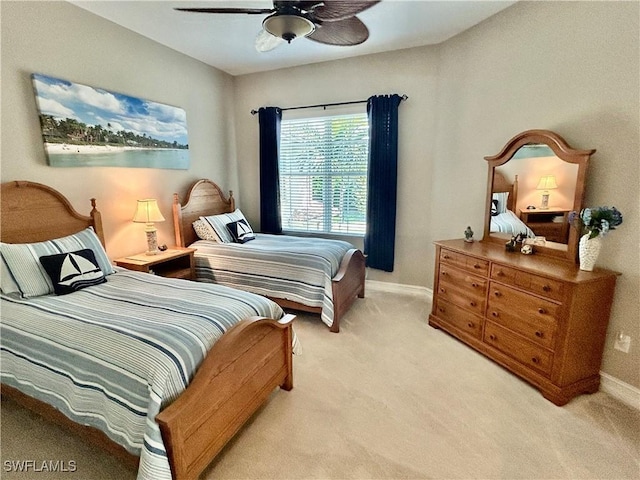 bedroom with light colored carpet, ceiling fan, and baseboards