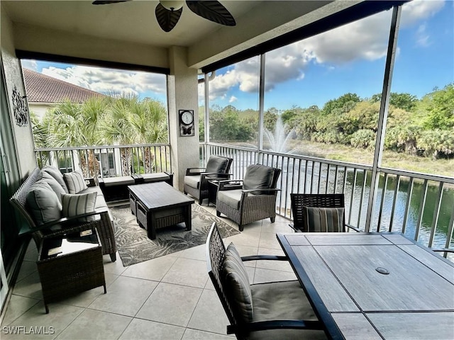 sunroom with a water view and ceiling fan