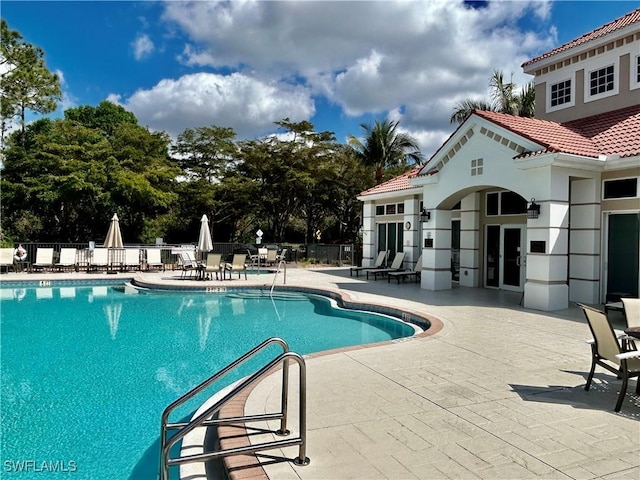 community pool featuring a patio area and fence