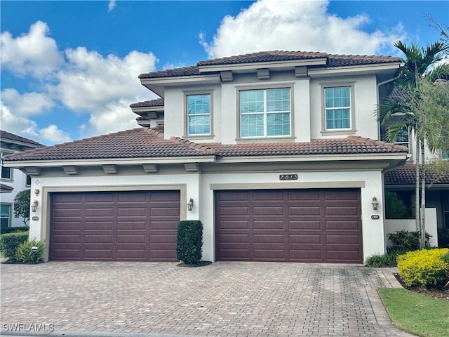 view of front of home with decorative driveway, a tile roof, and stucco siding