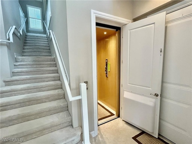 stairway featuring tile patterned flooring