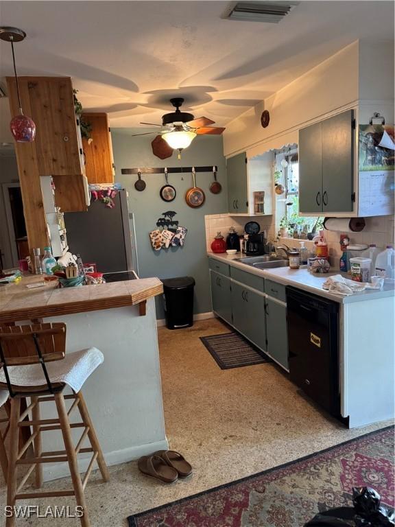 kitchen with ceiling fan, a sink, visible vents, freestanding refrigerator, and dishwasher