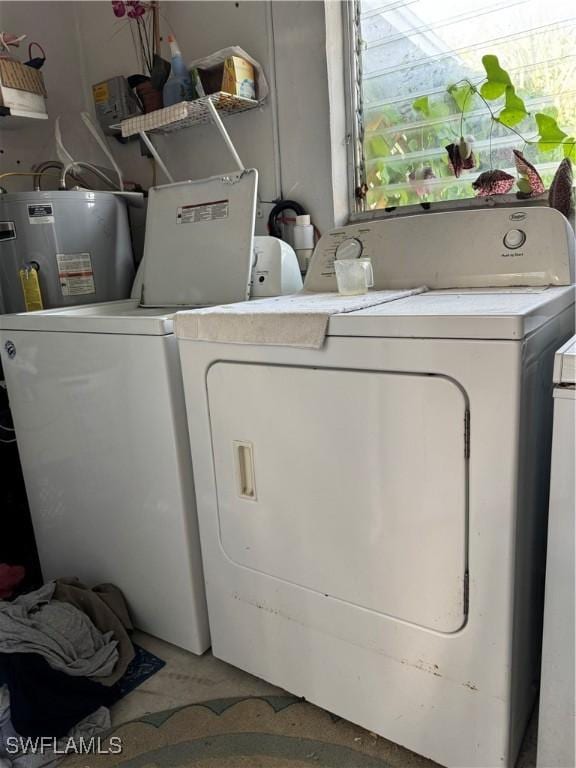 washroom featuring water heater, laundry area, and independent washer and dryer