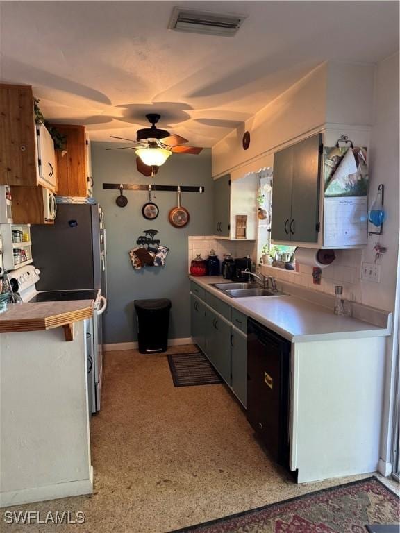 kitchen featuring visible vents, black dishwasher, decorative backsplash, a ceiling fan, and a sink