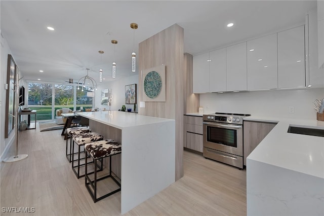 kitchen featuring a kitchen bar, modern cabinets, white cabinets, and electric stove