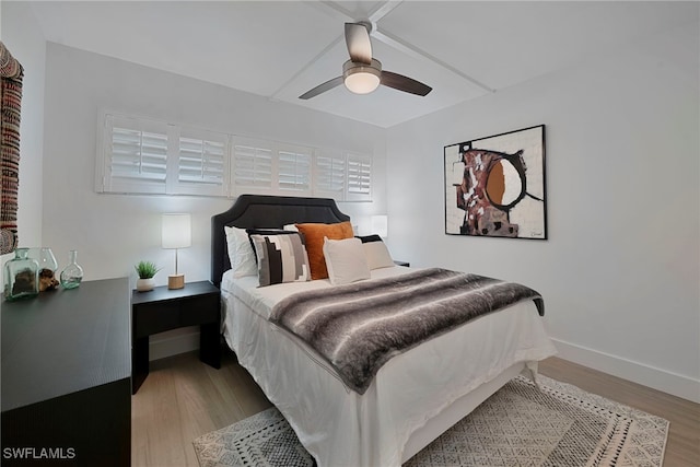 bedroom with wood finished floors, a ceiling fan, and baseboards