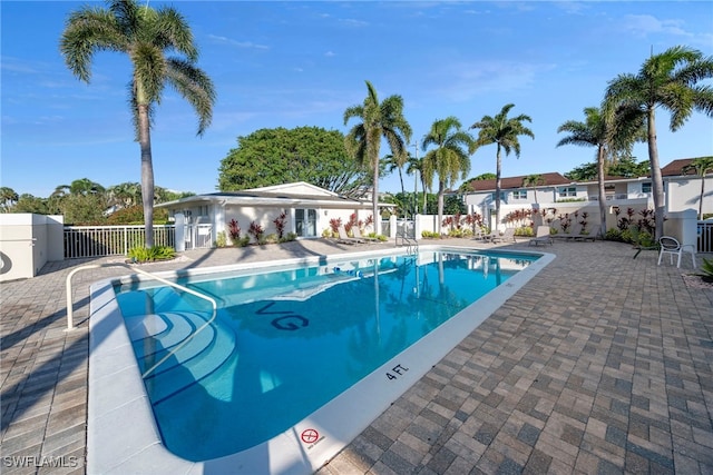 pool with a patio and fence