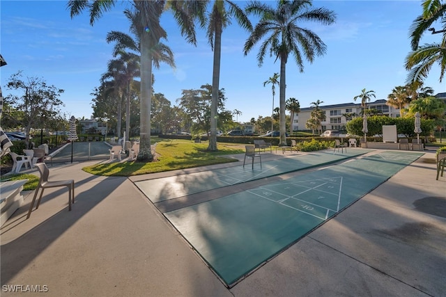 view of community with shuffleboard and a lawn