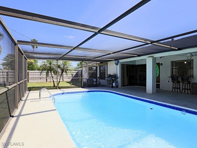 pool with a patio, area for grilling, a lanai, and fence