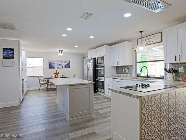 kitchen with tasteful backsplash, visible vents, and a sink