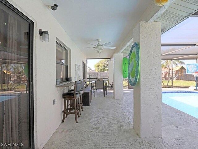 view of patio / terrace featuring a lanai, fence, a ceiling fan, a fenced in pool, and outdoor dining space